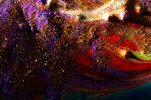 Multi-colored dark background sprinkled with purple and gold sparkles with streaks and waves. Contemporary creativity. A colorful avant-garde painting with rich texture. A background made up of many shapes and materials.