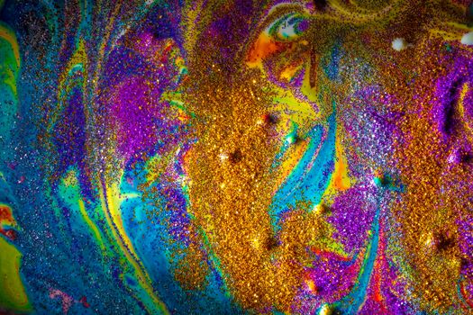Multicolored acrylic background with curls sprinkled with purple and gold sparkles. Contemporary creativity. A colorful avant-garde painting with rich texture. A background made up of many shapes and materials.