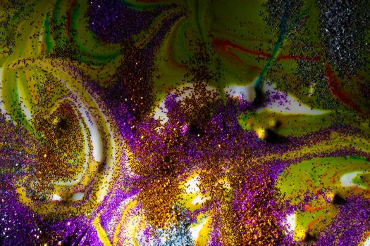Multi-colored dark background sprinkled with purple and gold sparkles with streaks and waves. Contemporary creativity. A colorful avant-garde painting with rich texture. A background made up of many shapes and materials.