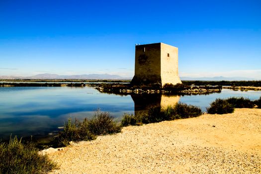 Beautiful Tamarit tower surrounded by salt lagoons in Santa Pola, Alicante, Spain