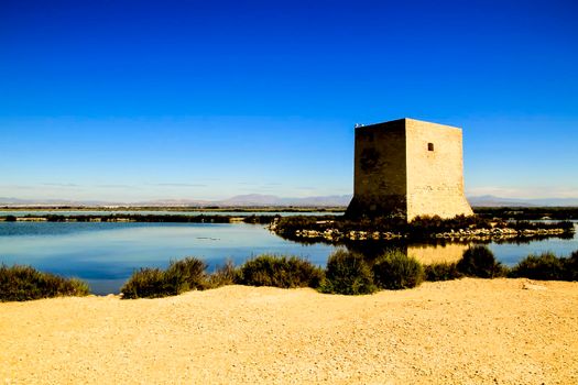 Beautiful Tamarit tower surrounded by salt lagoons in Santa Pola, Alicante, Spain