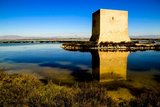 Beautiful Tamarit tower surrounded by salt lagoons in Santa Pola, Alicante, Spain