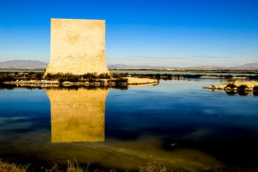 Beautiful Tamarit tower surrounded by salt lagoons in Santa Pola, Alicante, Spain