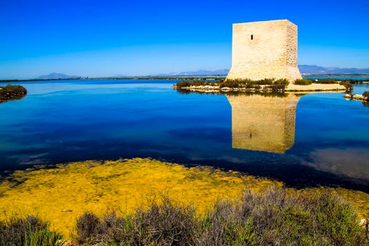 Beautiful Tamarit tower surrounded by salt lagoons in Santa Pola, Alicante, Spain