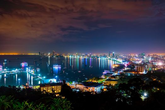 High view on viewpoint see cityscape with colorful light at the beach and the sea of Pattaya Bay, beautiful landscape of Pattaya City at night scene landmark in Chonburi, Travel Asia to Thailand