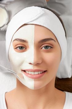 Top view portrait of attractive smiling young woman on cleaning face in beautician. Concept of special procedure for improvements and rejuvenation skin in professional beauty salon.