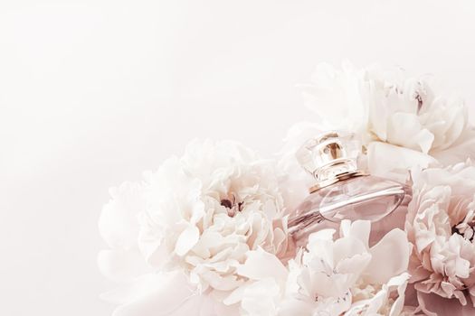 Fragrance bottle as luxury perfume product on background of peony flowers, parfum ad and beauty branding design