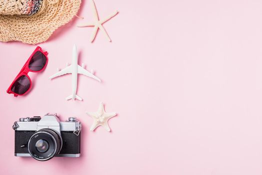 Top view flat lay mockup of retro camera films, airplane, hat, sunglasses, starfish beach traveler accessories on pink background with copy space, Business trip, and vacation summer travel concept