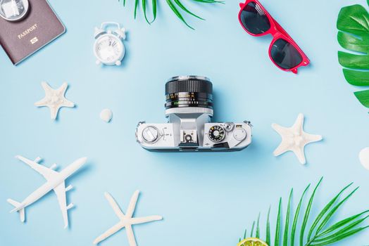 Flat lay top view mockup retro camera films, airplane, passport, starfish, shells traveler tropical accessories on a blue background with copy space, Vacation summer travel and business trip concept