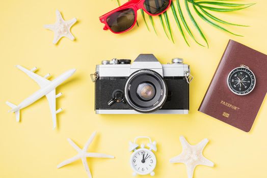Flat lay top view mockup retro camera films, airplane, passport, starfish traveler tropical beach accessories on a yellow background with copy space, Vacation summer travel and business trip concept