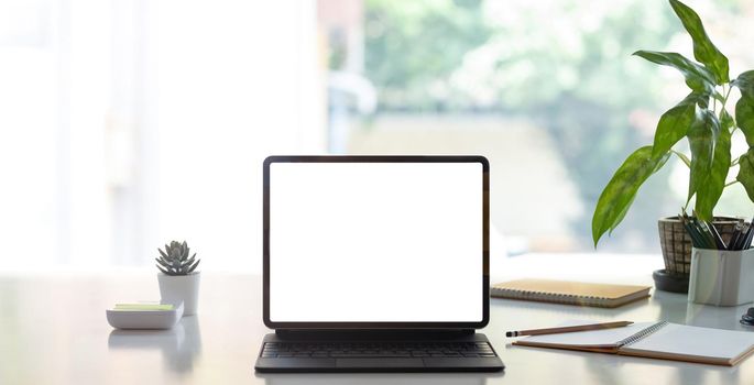 Digital tablet with white blank screen on table. workspace in modern office concept