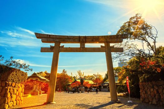 Osaka, Japan - 21 Nov 2018 -Old stone gate of shrine with sun rays in morning
