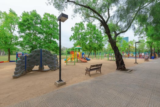 children playground activities in public park surrounded by green trees
