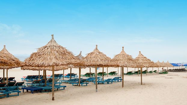 White sand beach with relaxing chairs at sunny day in Vietnam