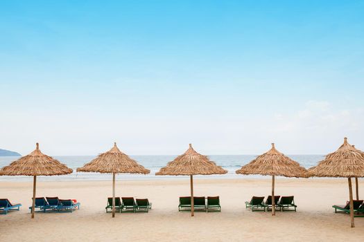 White sand beach with relaxing chairs at sunny day in Vietnam