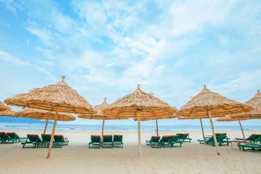 White sand beach with relaxing chairs at sunny day in Vietnam