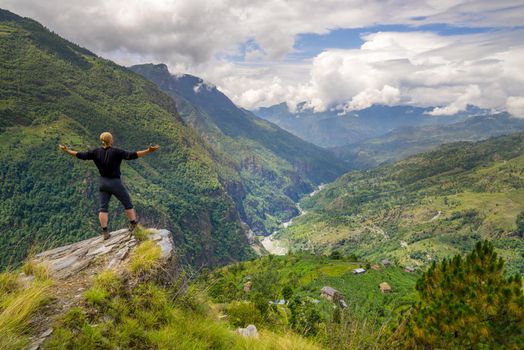 Man standing on top of the hill in Himalayas. Achievement and success. Trekking in Nepal