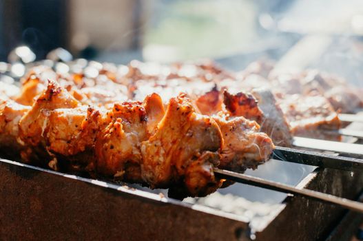 Cooking marinated pork kebabs on the grill. Fried pork kebabs on an open fire. Grill cooking season.