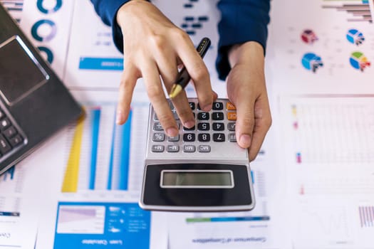 Top view. Accountant or business woman holding calculator and press button of calculator to calculate expenses, Accounting, financial. 