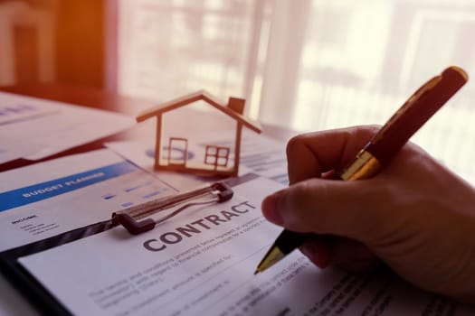 Realtor real estate or Banker Writing Contract Agreement about Rent, purchase, loan house. Offer of purchase house, rental of Real Estate Concept.