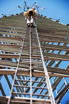 Climber ascending cell phone tower. Wisconsin, USA.