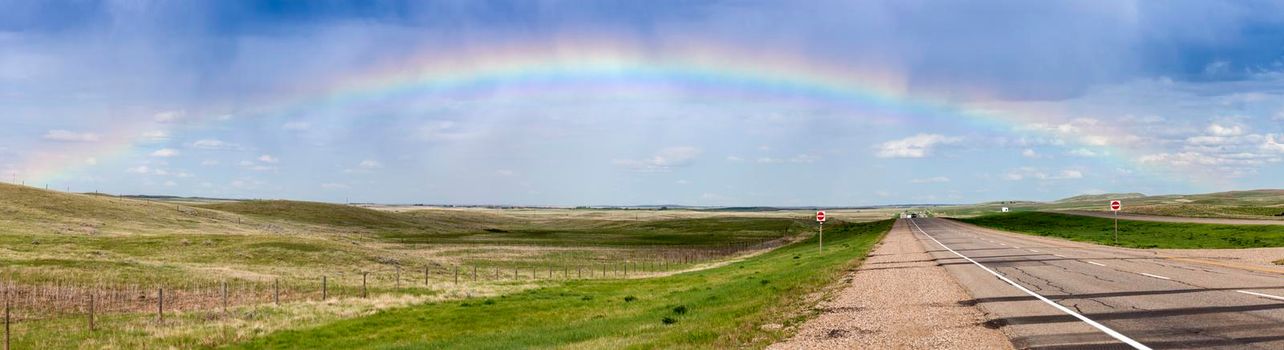 Rainbow over the highway in Saskatchewan. Saskatchewan, Canada.