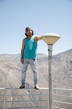 Attractive happy young tourist with cap with mountains background in Marcahuasi
