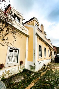 Lisbon, Portugal- March 6, 2020: Narrow and colorful streets with majestic facades, windows and balconies of Lisbon city in Portugal in a cloudy day