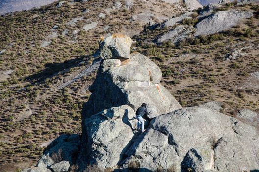 Traveling friends climbing the big rocks in Marcahuasi located east of the city of Lima - Peru