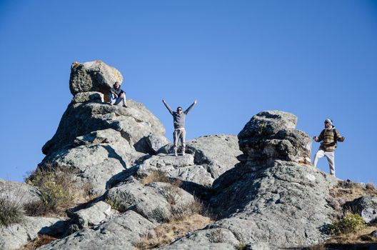 Traveling friends climbing the big rocks in Marcahuasi located east of the city of Lima - Peru