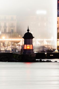 Geneva Lighthouse against a wall of water. Geneva, Switzerland.