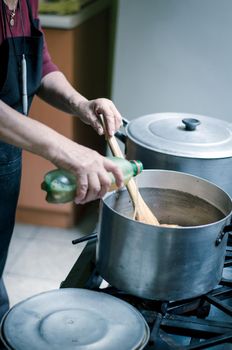 Hand of a woman adding ingredients to the pot where the food is cooking