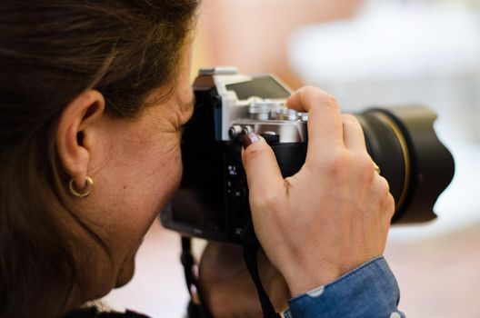 Photographer woman holding her black camera and taking photos