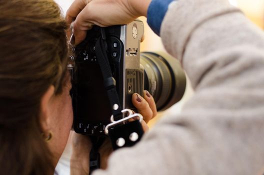 Photographer woman holding her black camera and taking photos
