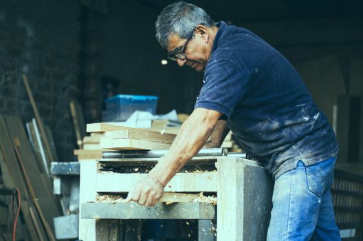 Carpenter using belt sander. Carpenter sanding a wood with belt sander