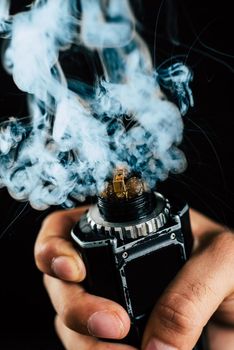 electronic cigarette mechanical mod closeup . a lot of steam . centered on a black background