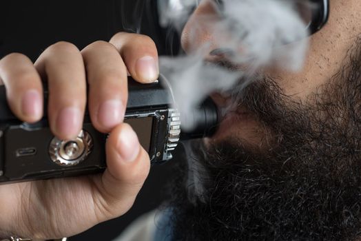 Close up of an unrecognizable young man smoking from a vape pen or vaporizer