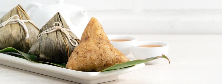 Zongzi. Rice dumpling for Chinese traditional Dragon Boat Festival (Duanwu Festival) on bright wooden table background.