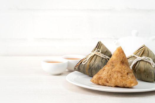 Zongzi. Rice dumpling for Chinese traditional Dragon Boat Festival (Duanwu Festival) on bright wooden table background.