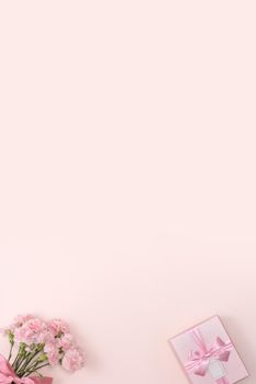 Mother's day background concept. Top view design of holiday greeting gift with carnation bouquet on bright pink table background