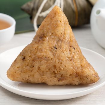 Zongzi. Rice dumpling for Chinese traditional Dragon Boat Festival (Duanwu Festival) on bright wooden table background.