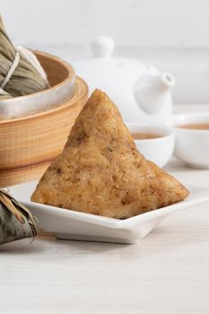 Zongzi. Rice dumpling for Chinese traditional Dragon Boat Festival (Duanwu Festival) on bright wooden table background.