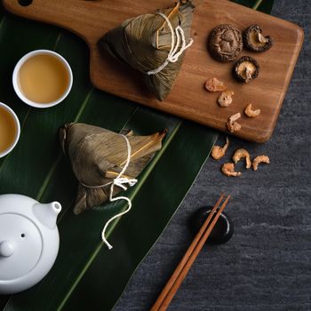Zongzi. Rice dumpling top view design concept for Chinese traditional Dragon Boat Festival (Duanwu Festival) over dark black slate background.