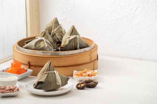 Zongzi. Rice dumpling for Chinese traditional Dragon Boat Festival (Duanwu Festival) on bright wooden table background with window.