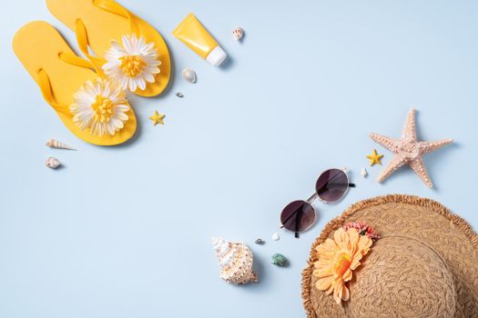 Summer beach background design concept. Top view of holiday travel with shells, hat, slipper on yellow background.