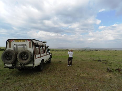 Woman tourist taking a photo of the beautiful African savannah, Kenya