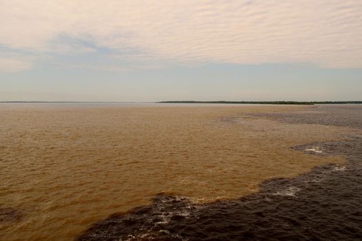 Meeting of Rio Negro and Rio Solimoes waters, Amazon, Brazil.