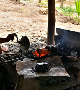 Closeup of a rudimentary bronze working process with fire