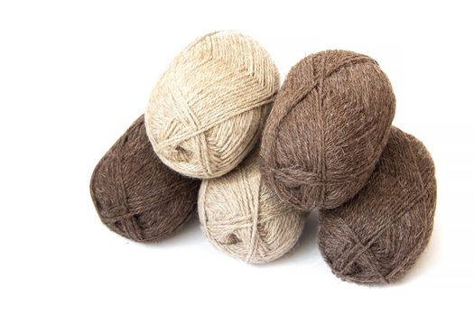 Wool yarns for knitting. Wool thread for knitting. Own hand. Knitting and needlework. Yarns for a scarf, sweater, and socks. Balls of yarn. Article about earning money at home with your hands. Article about knitting. Leisure for pensioners