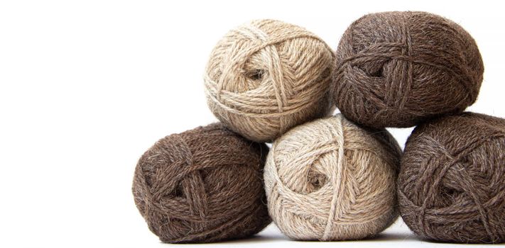 Wool yarns for knitting. Wool thread for knitting. Own hand. Knitting and needlework. Yarns for a scarf, sweater, and socks. Copy space . Balls of yarn